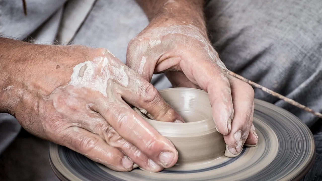 Mains qui façonnent un vase sur un tour de potier
