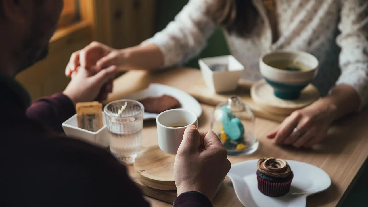 Deux personnes attablées autour d’un café, en pleine conversation